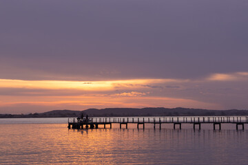 Naklejka na ściany i meble dock on the sea in the blue hour with violet sky