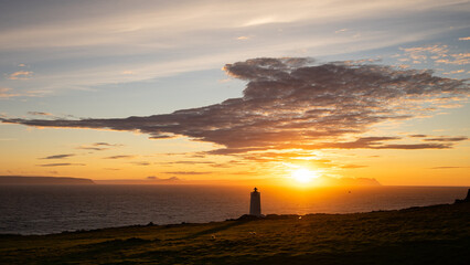 A dramatic sunset by a lighthouse in Northwest Iceland.