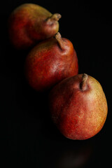 Fototapeta na wymiar three red pears on a black table