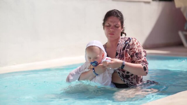 Mother with little boy in pool. Mother with baby boy playing and having fun on summer vacation in outdoor swimming pool