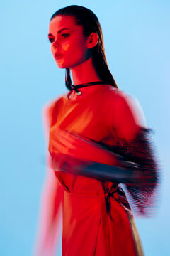 Young Woman Glamor Posing Red Light Metal Armor On Hand Blue Background