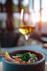 stewed mushroom with cream sauce or dill in bowl and wine glass in restaurant