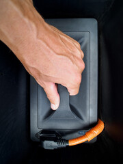 Hand changing Electric battery in moped scooter . Close-up.