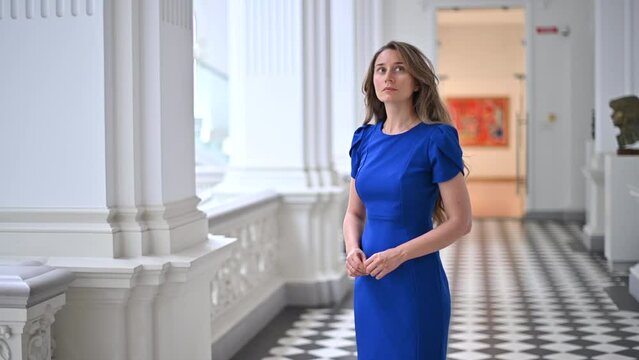 Woman wearing blue dress visiting a museum art gallery