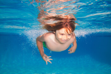 Kid swimming in pool underwater. Child boy swim under water in sea. Underwater children.