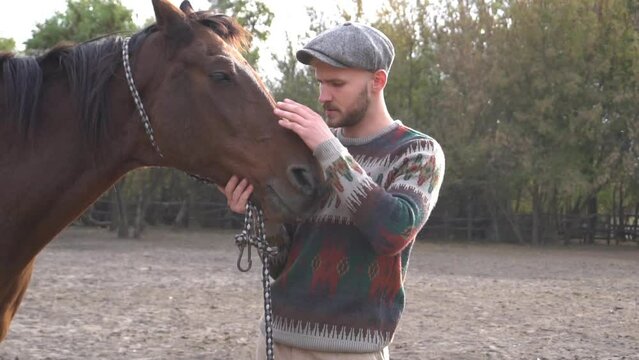 Guy with undercut hairstyle petting a horse at a ranch