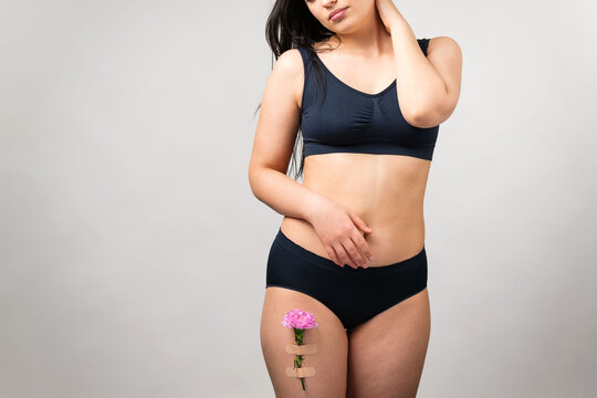 Cropped photo of a brunette woman wearing black lingerie set touching her neck with her hand and another hand keeping on the stomach.