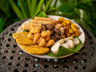 Picada de lomo langostinos apanados y yuca con fondo de plantas