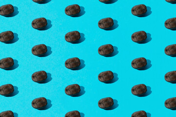 Arranged coffee seeds on a blue background. Pattern.