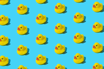 Yellow rubber toy duck on a blue background. Pattern.
