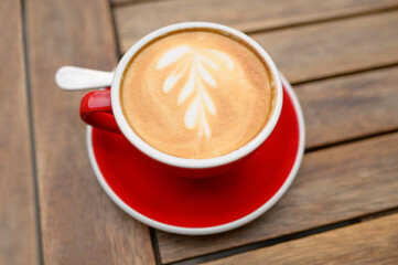 Cup of aromatic coffee on wooden table, above view