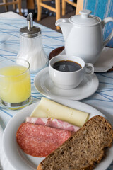 Desayuno con embutidos, pan, café y zumo