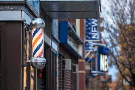 MONTREAL, CANADA - NOVEMBER 6, 2018: Typical American barbers pole seen in front of a barber shop of Montreal, Canada. This pole is a vintage sign indicating the presence of a male hairdresser salon