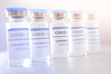 Coronavirus vaccine ampoules on light background - vaccination medical concept