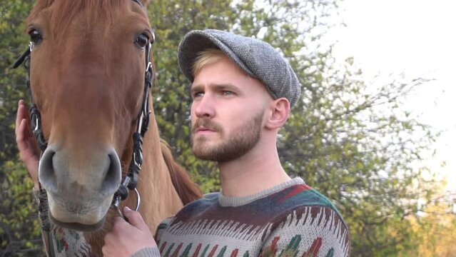 The young man with a horse on a farm