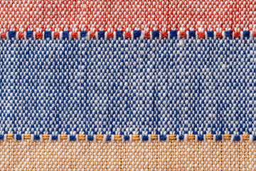 Plain weave fabric macro background. Textile with horizontal strips of red, blue, yellow colors....