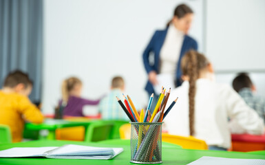 Pencils and notebooks on blurred background of elementary school students. High quality photo