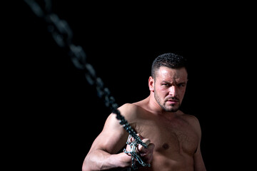 Seductive face of a sexy man athlete holding a chain. Macho looking confident. Strong muscular male body, muscles guy.