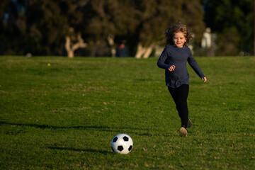 Cute boy kicking soccer ball. Sports kid during soccer training. Soccer boy, child play football.