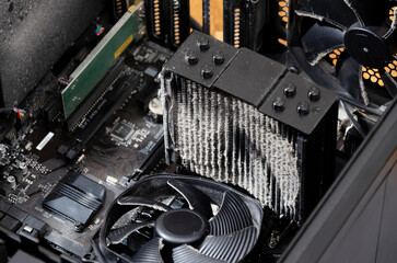 Dirty CPU cooler heatsink. Dust on the air fan for the processor. System unit with dust from the...