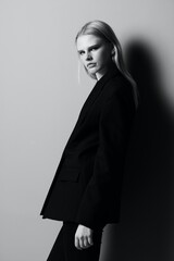 Naklejka premium Young beautiful stylish girl posing leaning on the wall in the studio