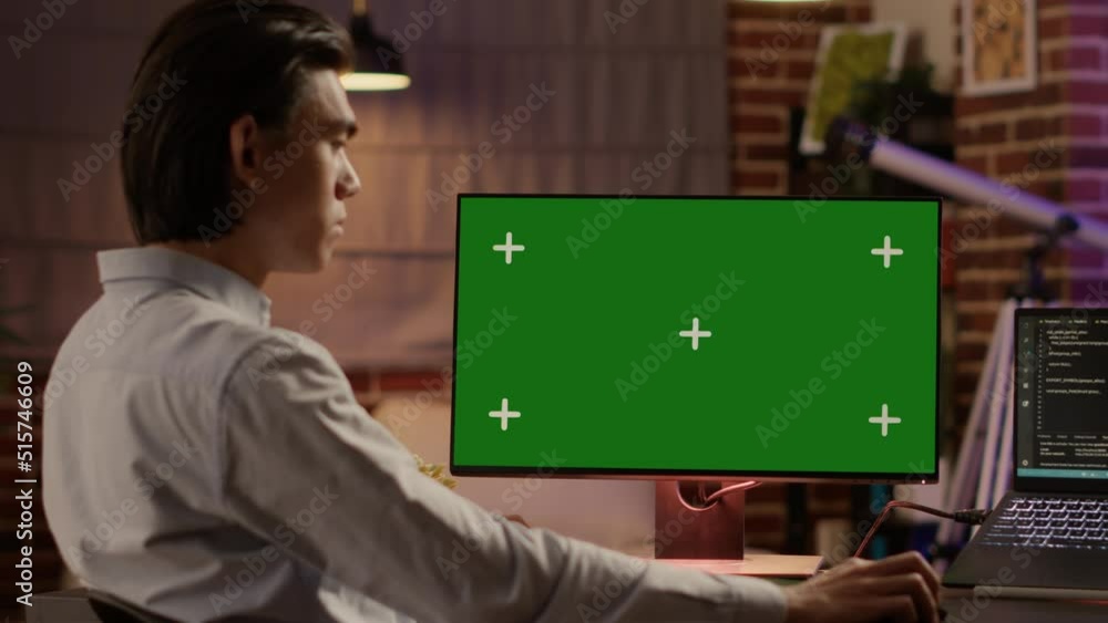 Poster male freelancer using computer display with greenscreen to work on business. looking at isolated chr