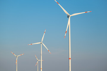 Green energy.Wind generator on blue sky background.Natural energy.Windmill on sky background. renewable energy.Alternative sources.Environmentally friendly natural energy source.