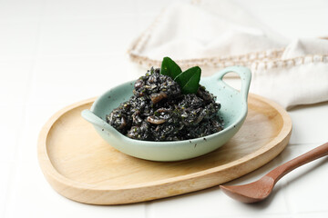 Stir Fried Squid and Chili in Black Squid Ink Sauce Served in Ceramic Plate. Known as Tumis Cumi Hitam Pedas In Indonesia.