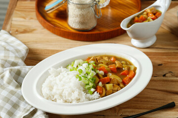 Japanese Curry Rice with Meat, Carrot and Potato. Close Up on White Plate on Wooden Table.