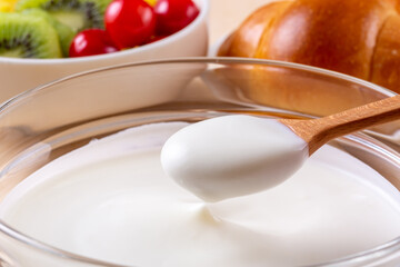 朝食のヨーグルトをスプーンで掬う