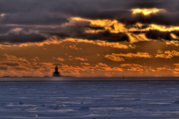 lighthouse with frozen water at sunset