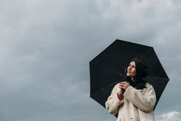 person with umbrella. Sky background. happy day. Fashion photo. Rain 