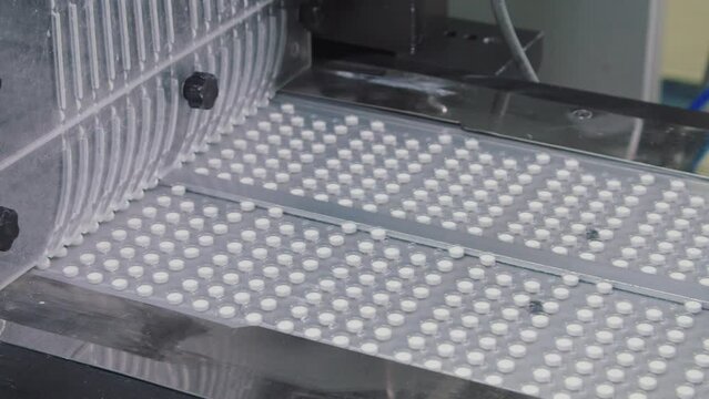 The packaged pills in blister move along the conveyor belt. automated assembly line during the process. stage of pharmaceutical fabrication.