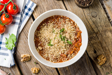 bean lobio in a pot megrelian with walnuts top view on wooden table