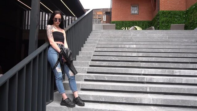 Pretty girl posing with phone on stairs in the city