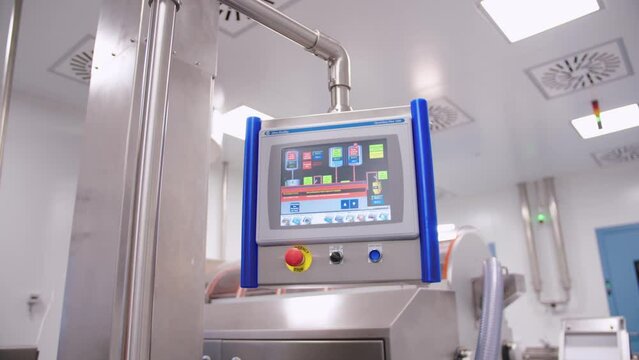 Pharmaceutical automated machinery. industrial production line in a modern factory. computer operating display on medical equipment.