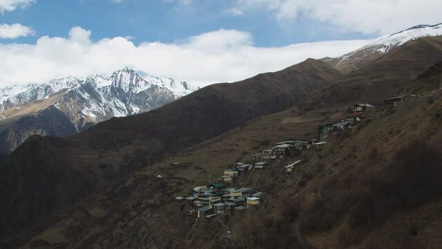 Breathtaking view of authentic village surrounded by majestic mountains. caucasian aul among the scenic mountain landscape with snow peaks in republic of dagestan.