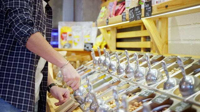 man is buying nuts in grocery, shopping healthy food in supermarket