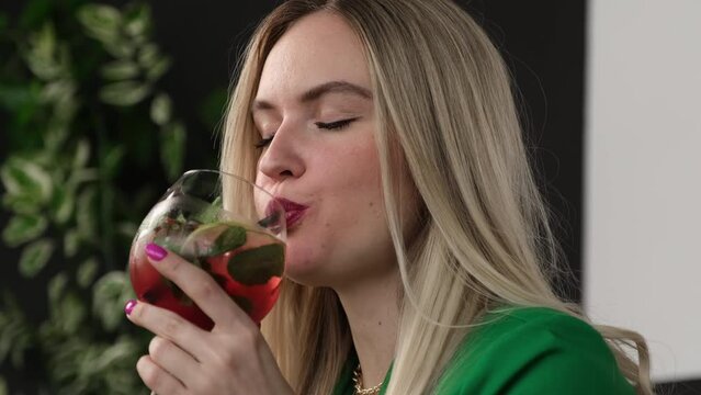 Blonde with pleasure drinking a delicious cocktail