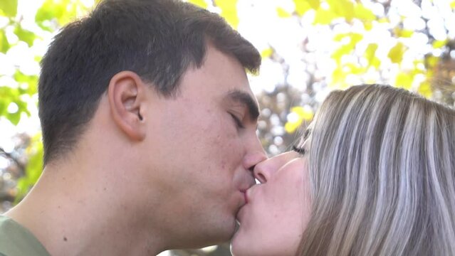 Slow Motion Husband and His Wife Kissing on a Sunny Meadow in the Autumn Forest.