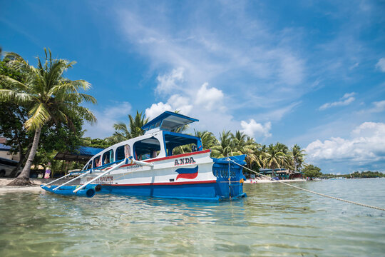 Anda, Pangasinan, Philippines - June 2022: A small outrigger boat used to ferry tourists docked at Tondol Beach during high tide.