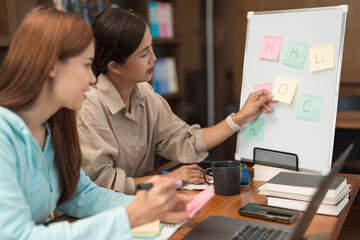 College education concept, Teenage girl looking vocabulary on whiteboard and writing on sticky note