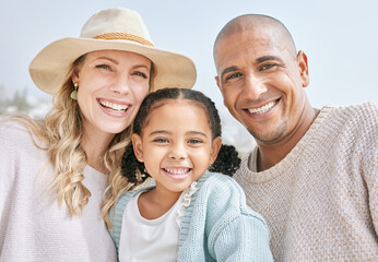 Portrait of an interracial happy family bonding while on a beach vacation together. Cute little...