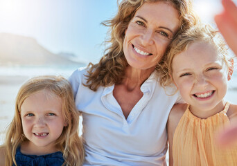 Portrait of a happy family taking a selfie at the beach while on a vacation in summer. Mature woman...