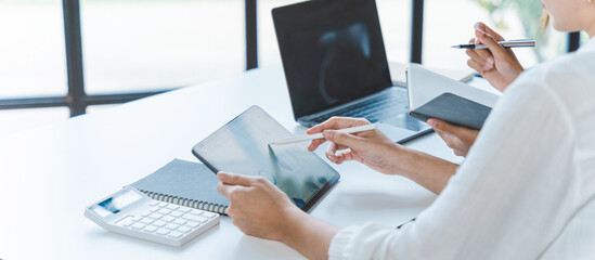 Two young Asian businesswoman discuss investment project working and planning strategy. Business...