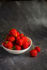 strawberries in a bowl on a wooden table