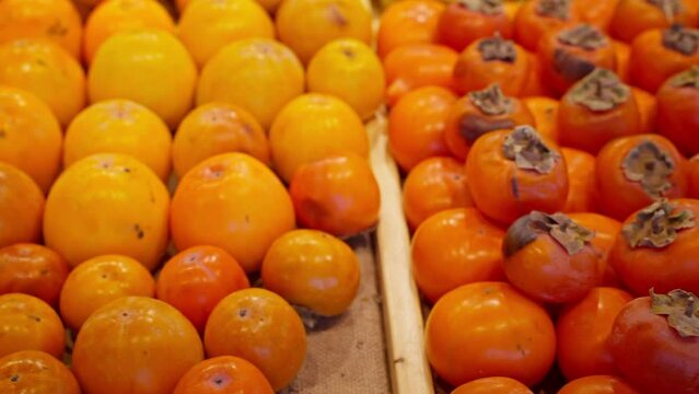 fruit showcase in supermarket or grocery, ripe persimmon, useful and healthy food