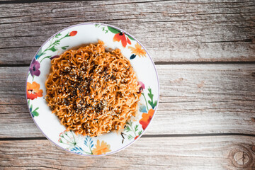 Noodles or spicy Hakka Noodles or Chow Mein in white plate at wood background. Schezwan Noodles is indo-chinese cuisine hot dish with udon noodles, seaweed and chilli sauce.