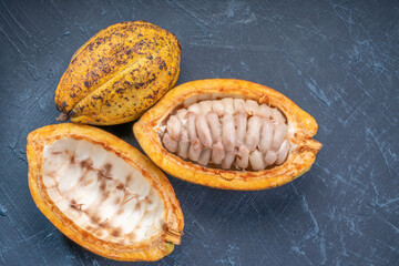 Yellow Cocoa fruit and fresh cocoa beans on black wooden background.