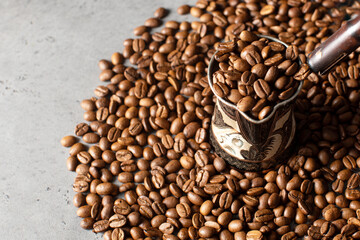 Turk with roasted coffee beans and grains around on a gray background. Copy space.